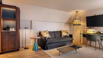 A modern living room with a sofa, coffee table, and a desk with a chair.
