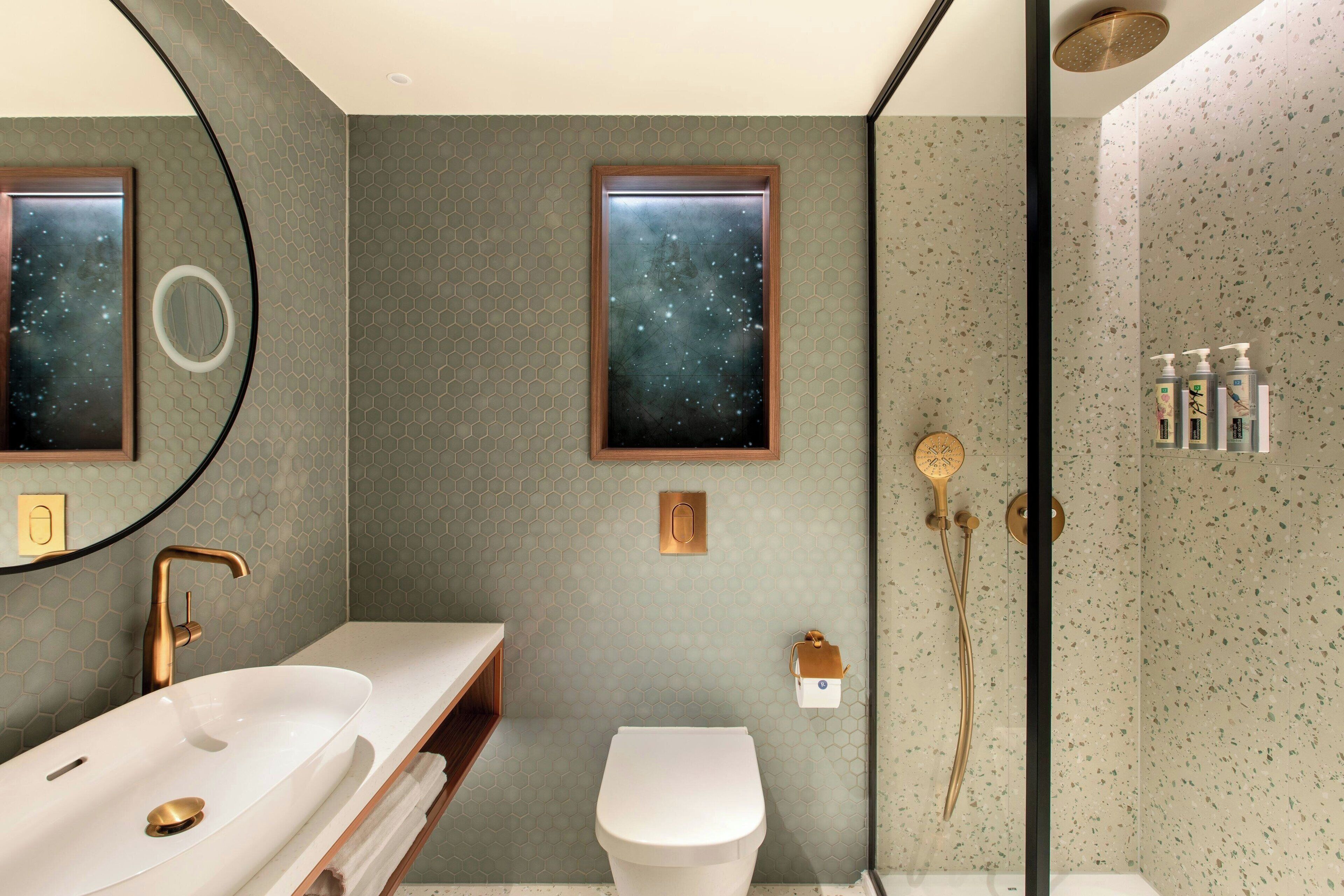 Een moderne badkamer met een groot wastafel, toilet en douchehoek.