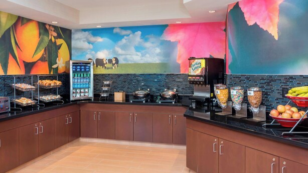 A modern kitchen with a mural, a self-serve station, and a variety of food options. - Fairfield Inn & Suites by Marriott Temple Belton (Temple)