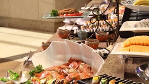 A buffet with various seafood dishes, including shrimp and sushi. - Hotel New Century Beijing (Beijing)