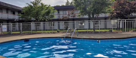Una piscina al aire libre, sombrillas, tumbonas