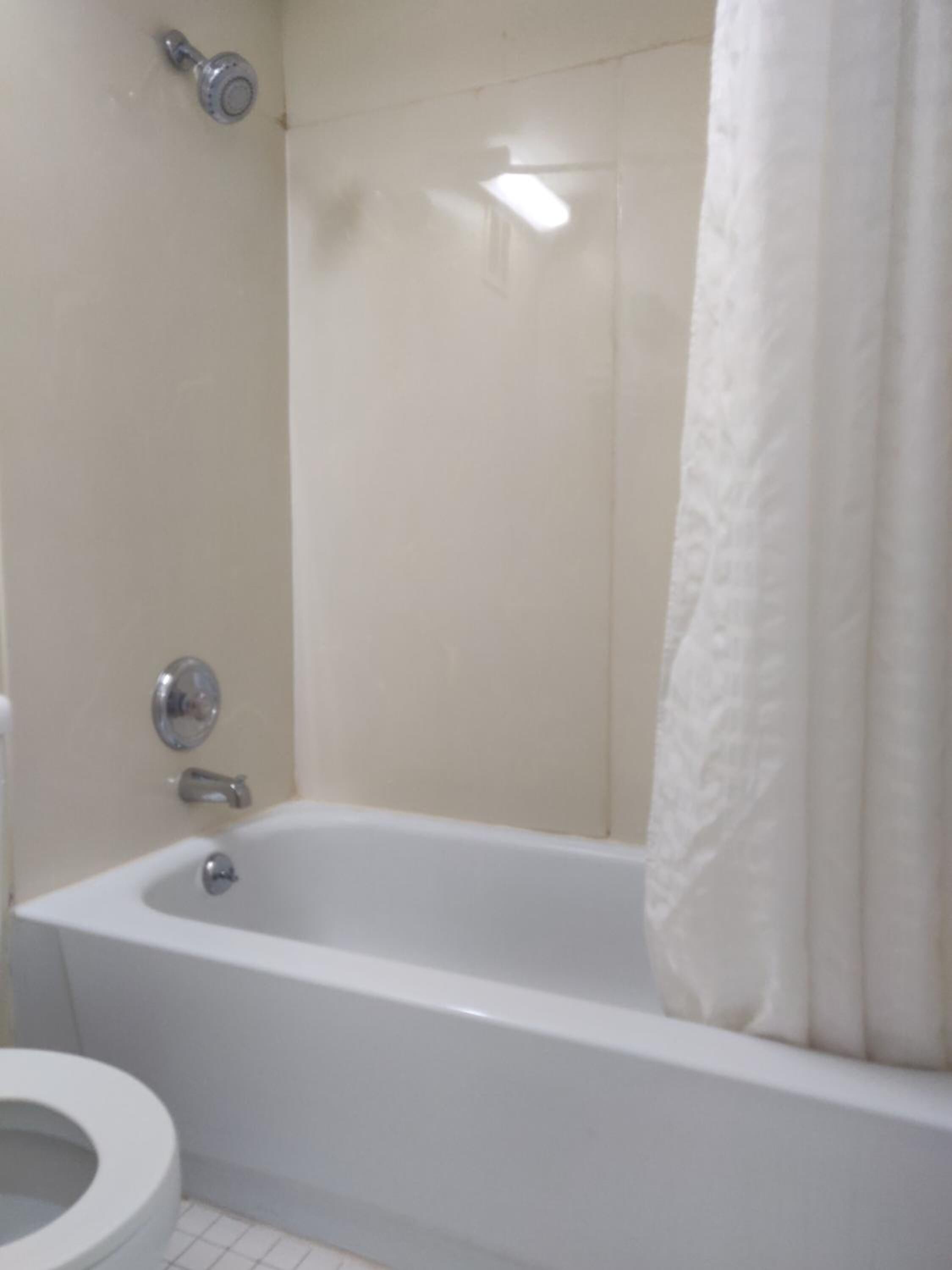 Un baño con bañera, inodoro y ducha.