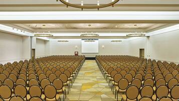 A conference room with rows of chairs facing a projection screen.