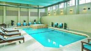 An indoor swimming pool with lounge chairs and a small seating area. - Sheraton Portland Airport Hotel (Portland)