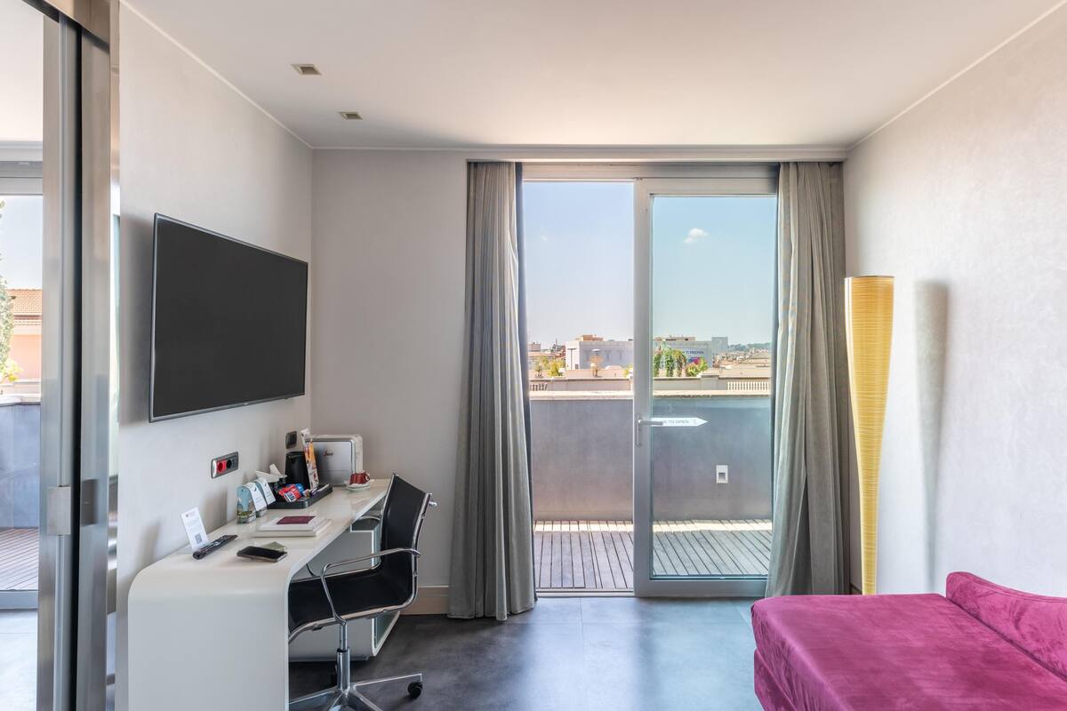 Een hotelkamer met een bureau, stoel en een bed.