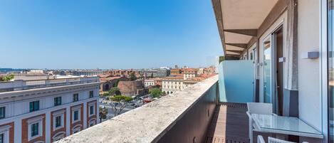 A balcony with a clear view of the cityscape, including historic buildings and a modern structure.