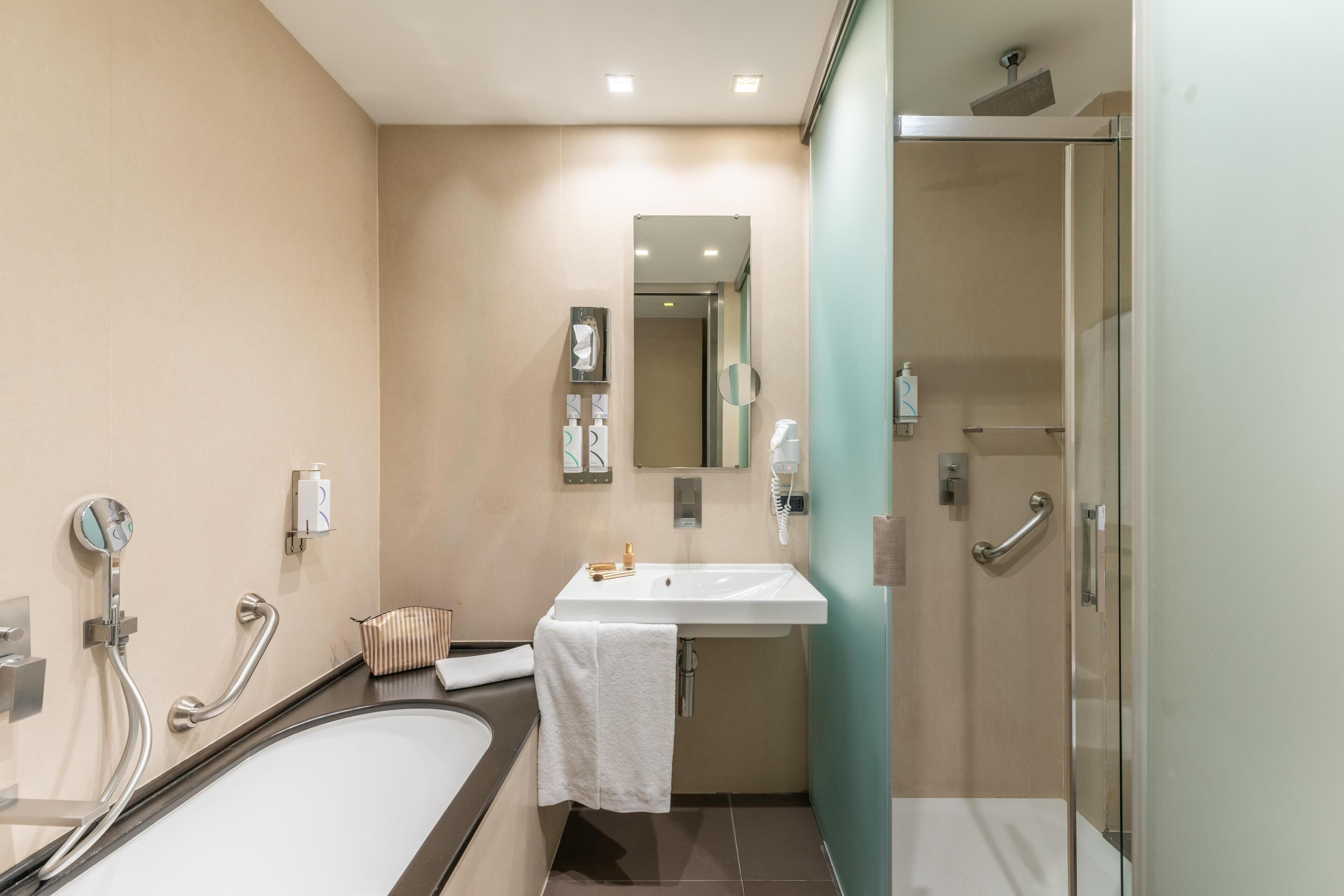 Ein modernes Badezimmer mit Badewanne, Waschbecken und Dusche.