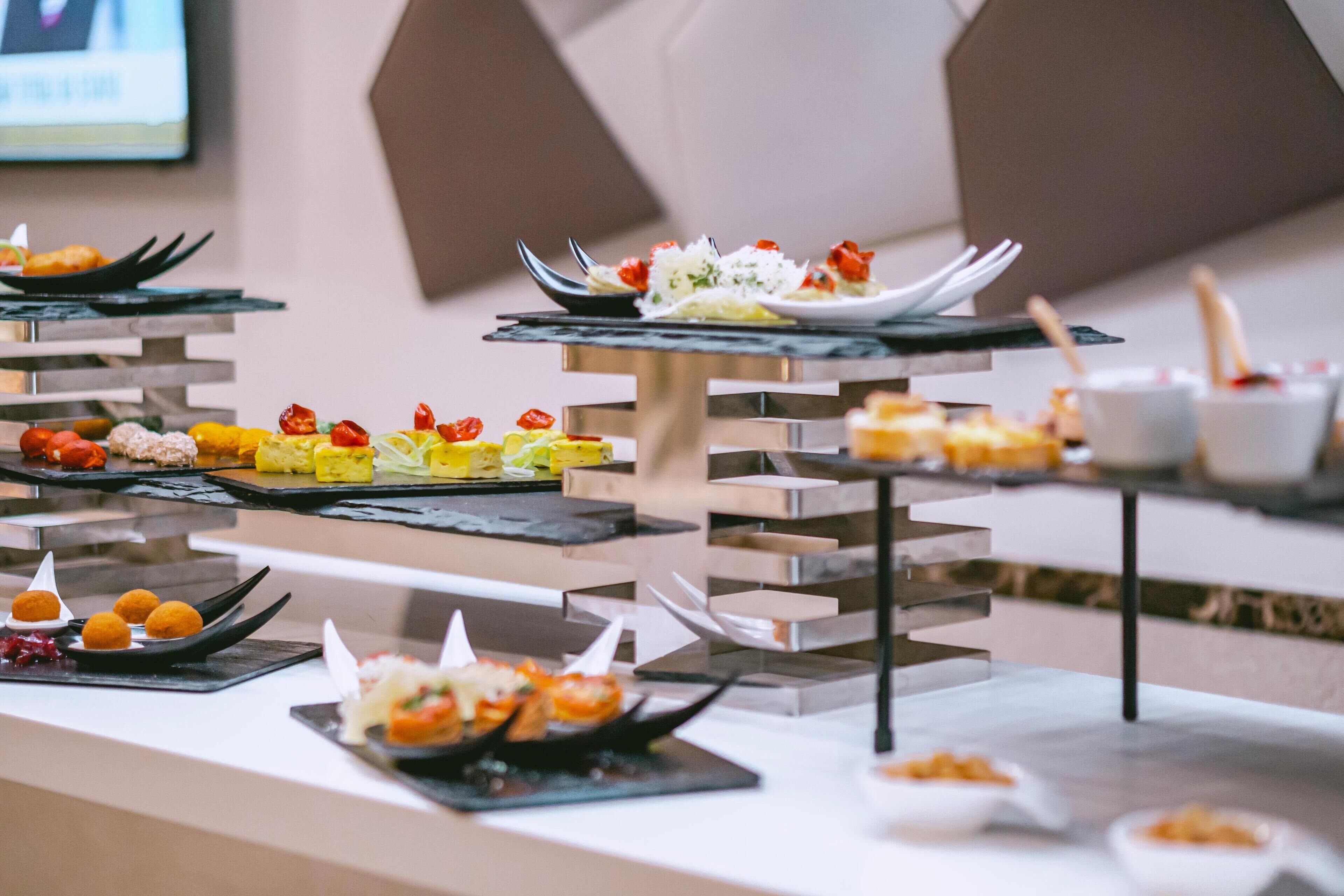 A buffet with various dishes arranged on tiered stands.