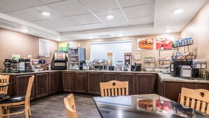A clean, well-lit kitchen area with a counter, seating, and various appliances.