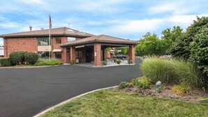 A brick building with a covered entrance and a flagpole.