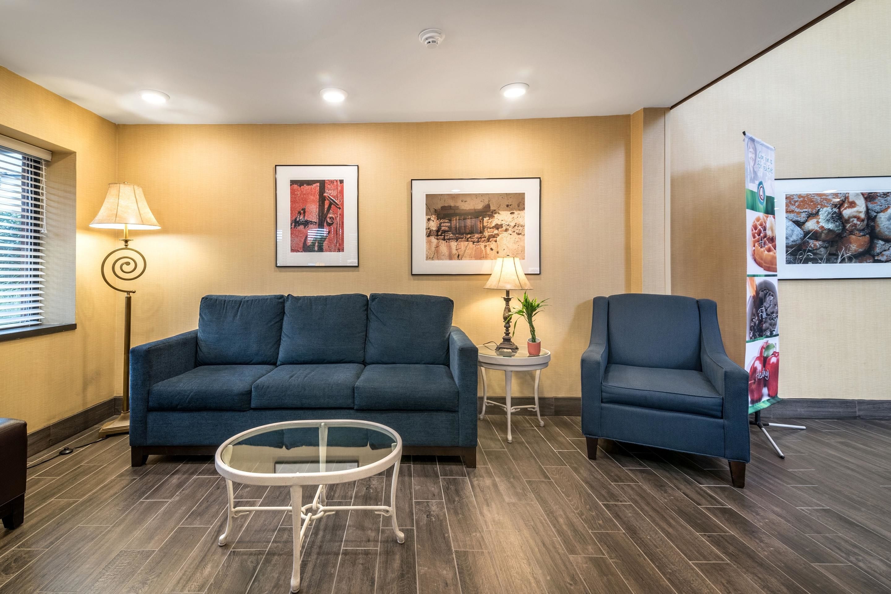 Un salon moderne avec un canapé, un fauteuil et une table basse en verre.