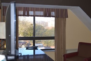 A room with a large window, a desk, and a chair.