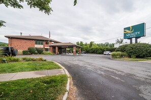 A Quality Inn with a brick building, a covered entrance, and a large sign.