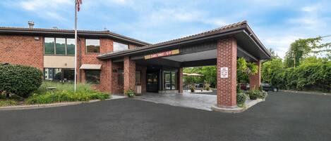 A brick building with a covered entrance and a sign indicating 'CARS ONLY - 8 FT'.