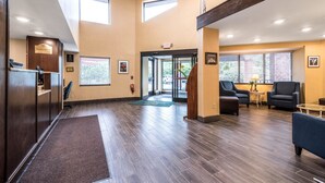 A reception area with a reception desk, a waiting area with sofas, and a staircase leading to an upper level.