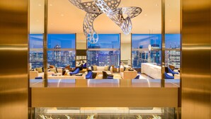 A modern hotel lobby with a city view, a large butterfly sculpture, and comfortable seating areas. - The Prince Gallery Tokyo Kioicho, a Luxury Collection Hotel (Tokyo)