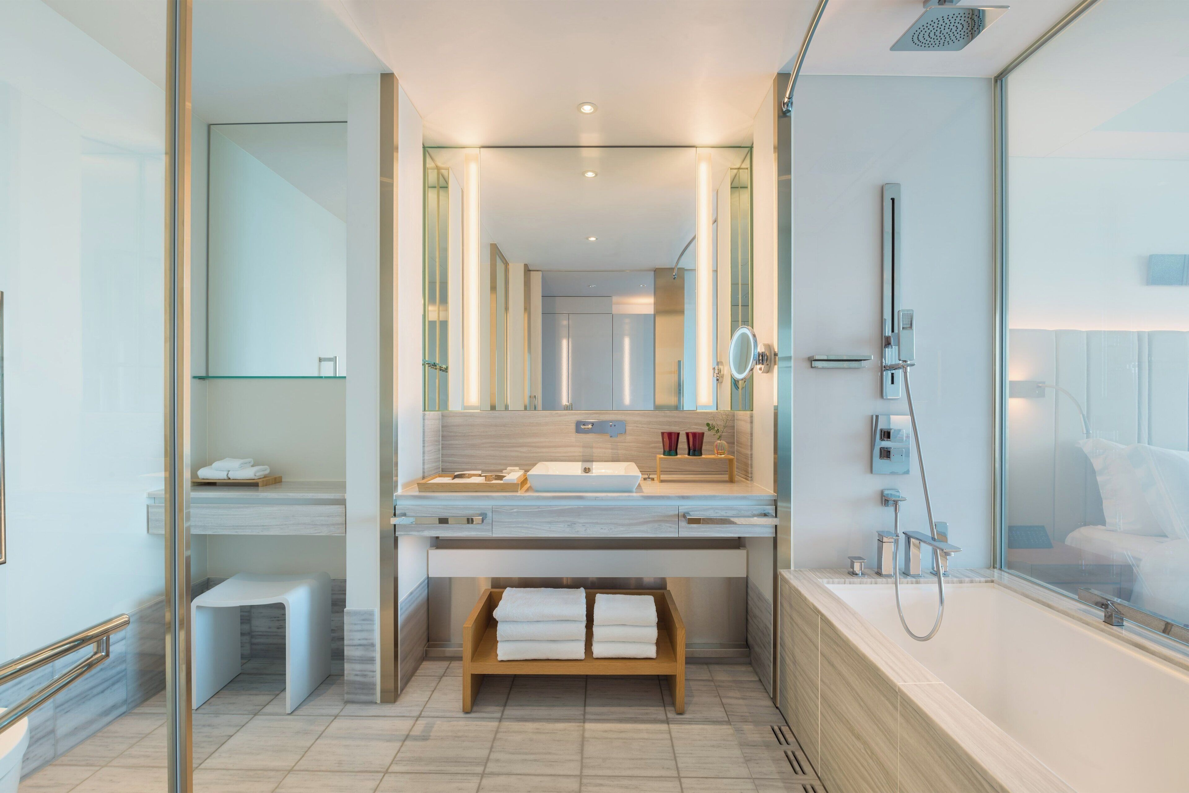 A modern bathroom with a large sink, mirror, and shower.