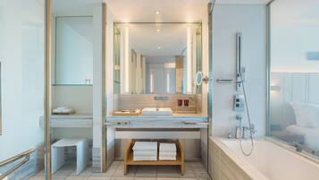 A modern bathroom with a large sink, mirror, and shower.