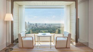 A modern room with a large window, a table with two chairs, and a floor lamp. - The Prince Gallery Tokyo Kioicho, a Luxury Collection Hotel (Tokyo)