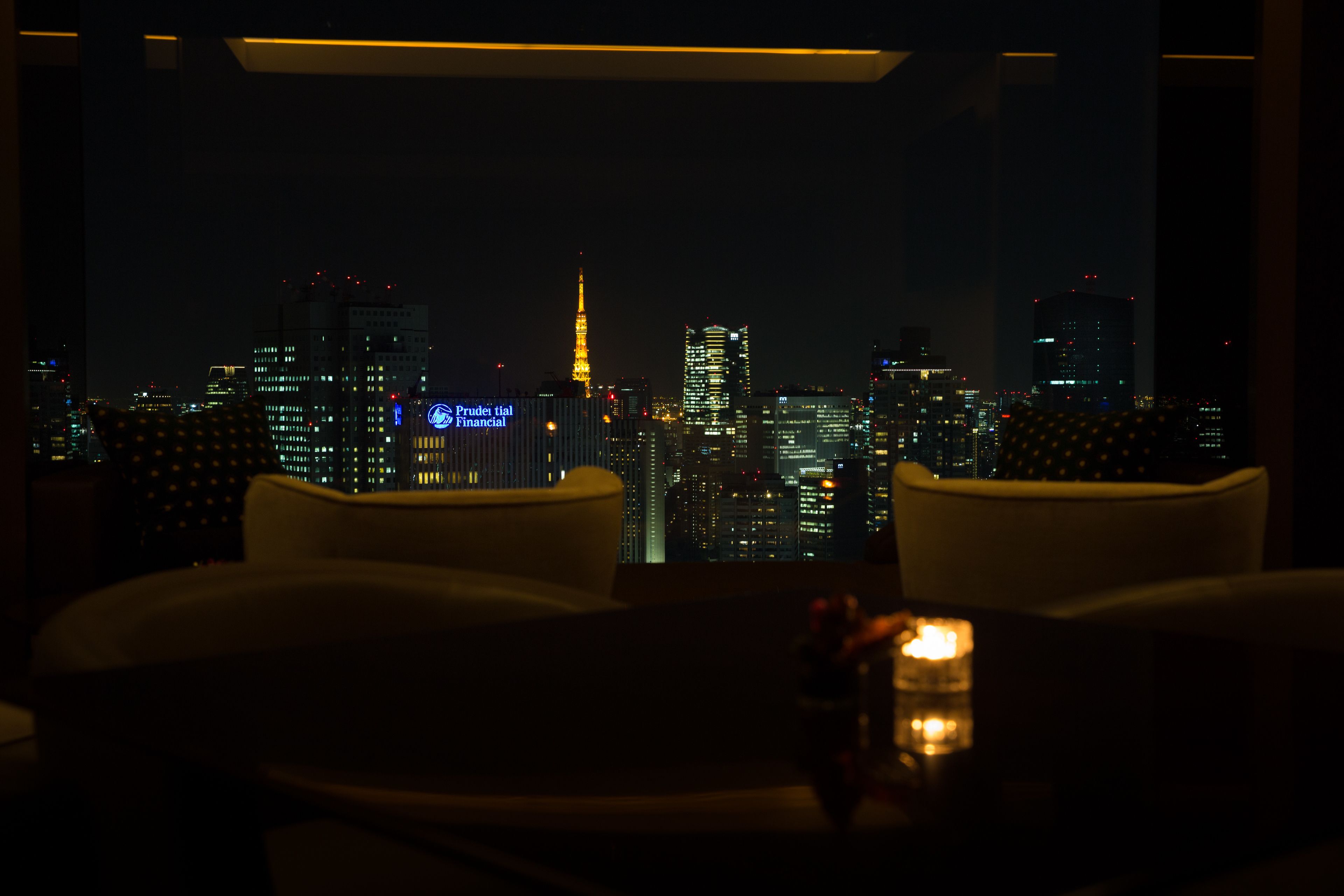 A dimly lit room with a view of a city skyline at night.