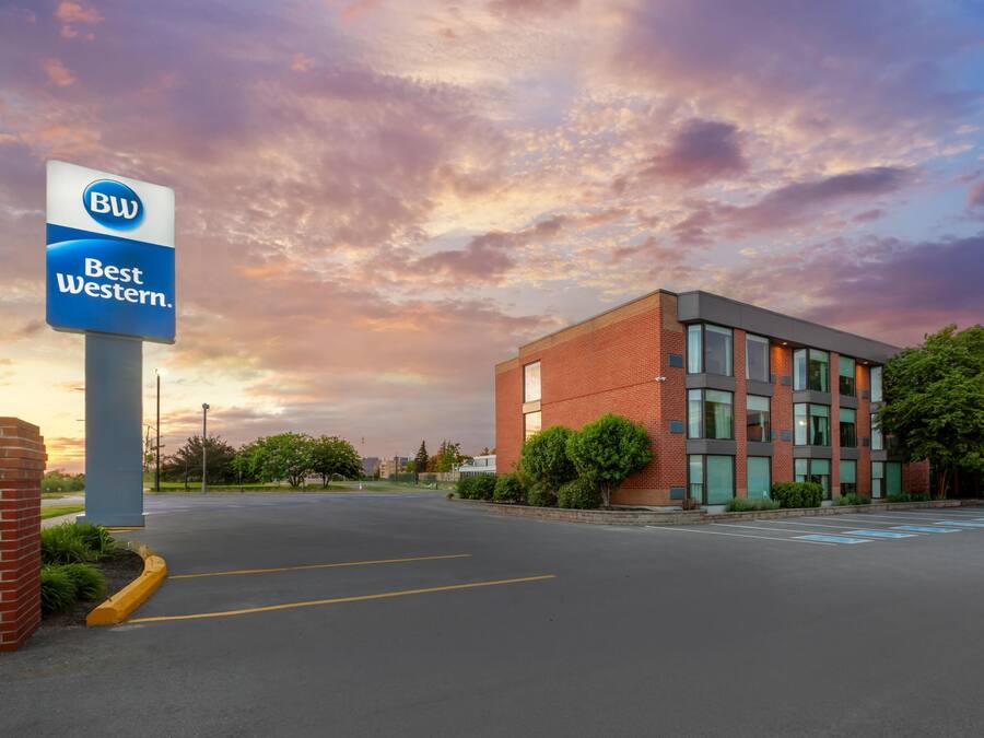 Um hotel Best Western com um edifício moderno de tijolos, um estacionamento e céu limpo.