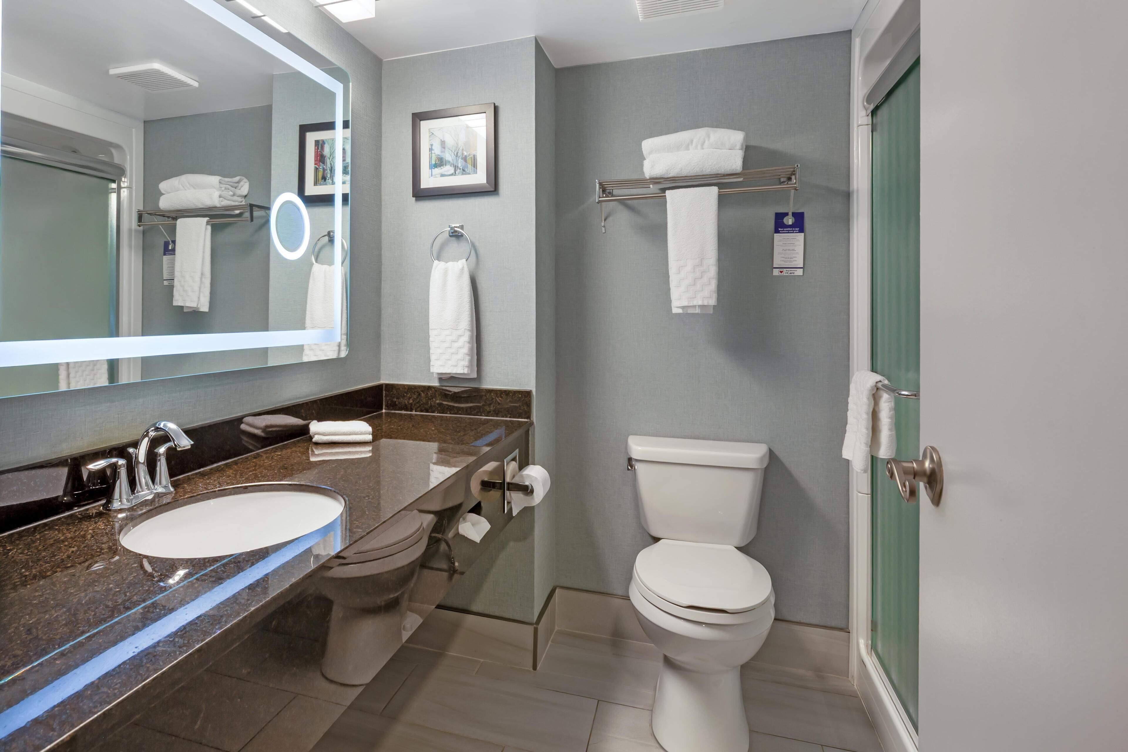 Un baño moderno con lavamanos, inodoro y ducha.