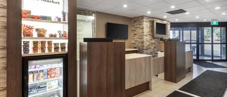 A reception area with a 'The Market' refrigerated display, a reception desk, and a stone accent wall.