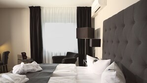 A hotel room with a large bed, a chair, a desk, and a lamp. - TRYP by Wyndham Bremen Airport (Bremen)