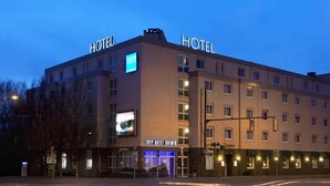 A hotel with multiple floors, a prominent 'HOTEL' sign on the roof, and a 'TRYP HOTEL BREWER' sign on the ground floor. - TRYP by Wyndham Bremen Airport (Bremen)