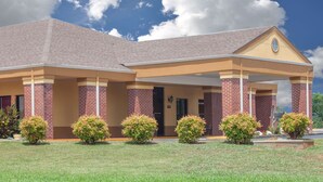 A two-story building with a covered entrance and brick facade. - Days Inn by Wyndham Moulton (Moulton)