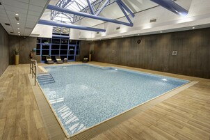 Una piscina techada, sillones reclinables de piscina