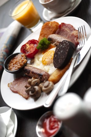 Savor a traditional full English breakfast, served with sausages, eggs, mushrooms, baked beans, and fresh tomato.