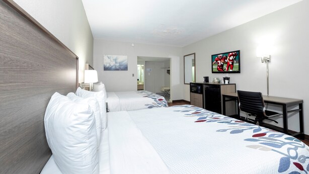A hotel room with two beds, a desk, a chair, a television, and a mirror. - Red Roof Inn Petersburg - Fort Lee (Petersburg)