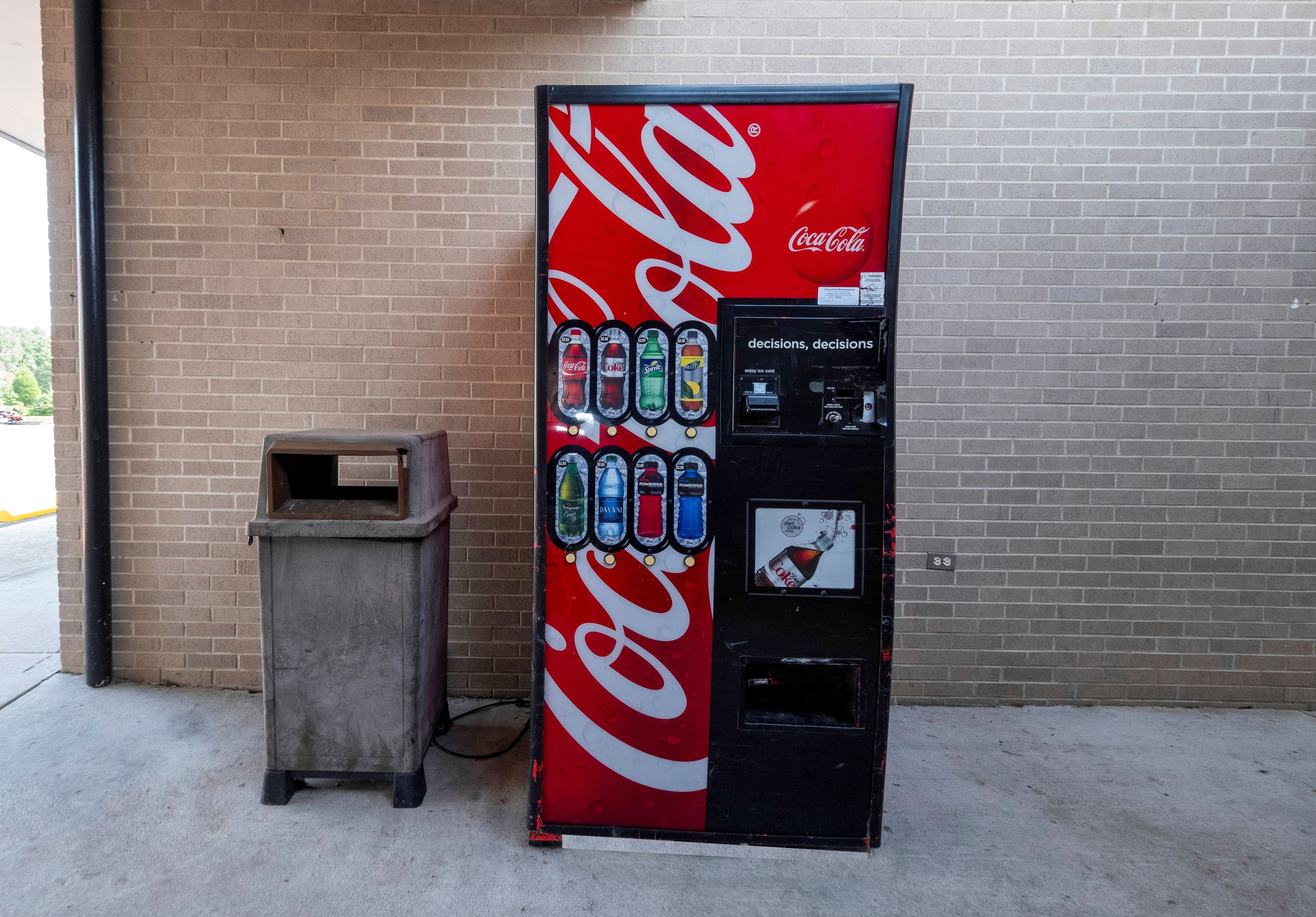 En försäljningsautomat för Coca-Cola med ett stort utbud av drycker och en myntinkast.