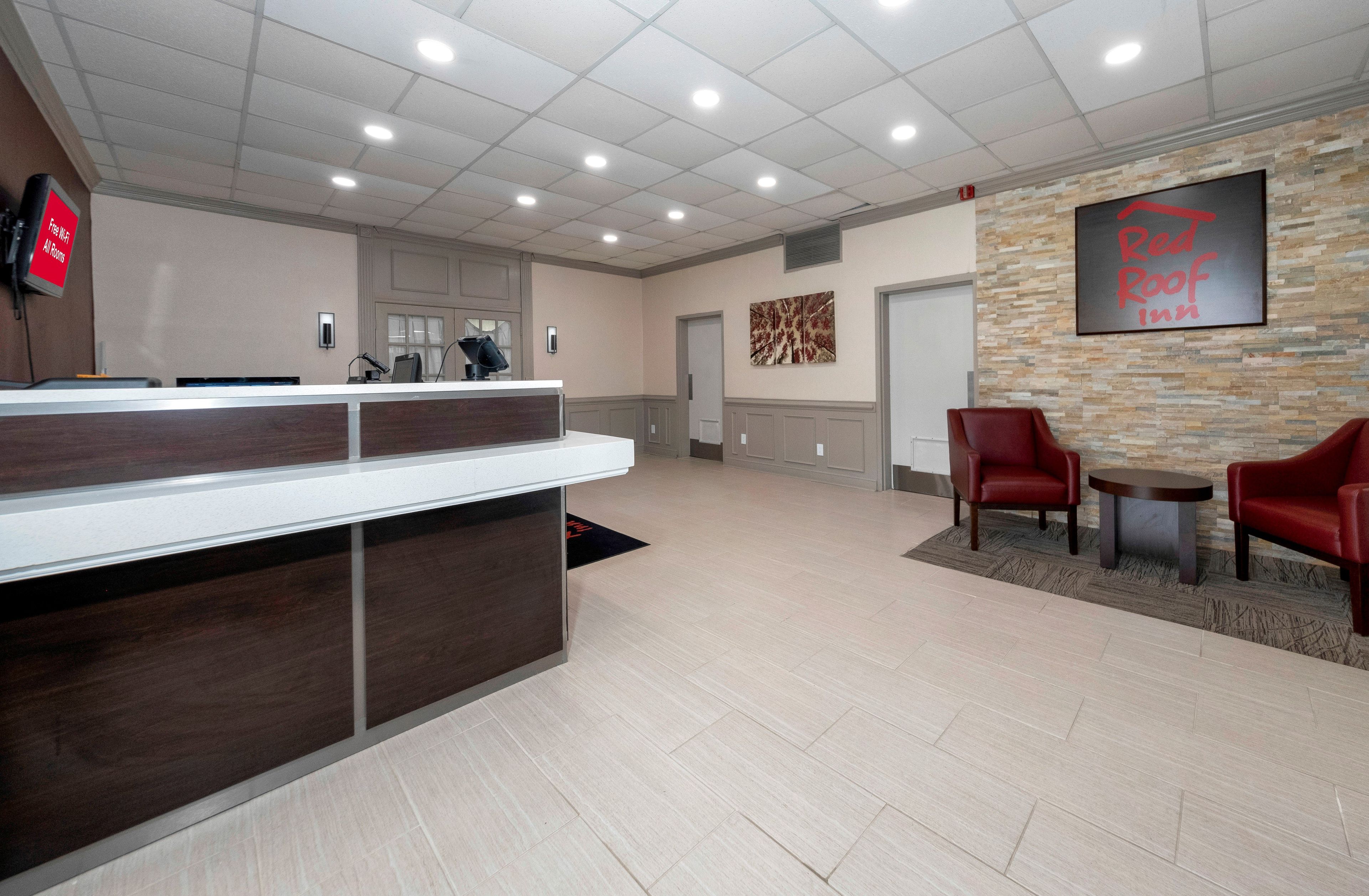 A reception area with a counter, a fire extinguisher, a wall-mounted sign, and a framed artwork.