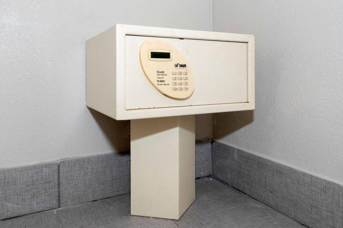 Un dispositivo bianco, autoportante e fissato al muro, dotato di una tastiera e un display digitale, probabilmente un sistema di sicurezza o controllo accessi.