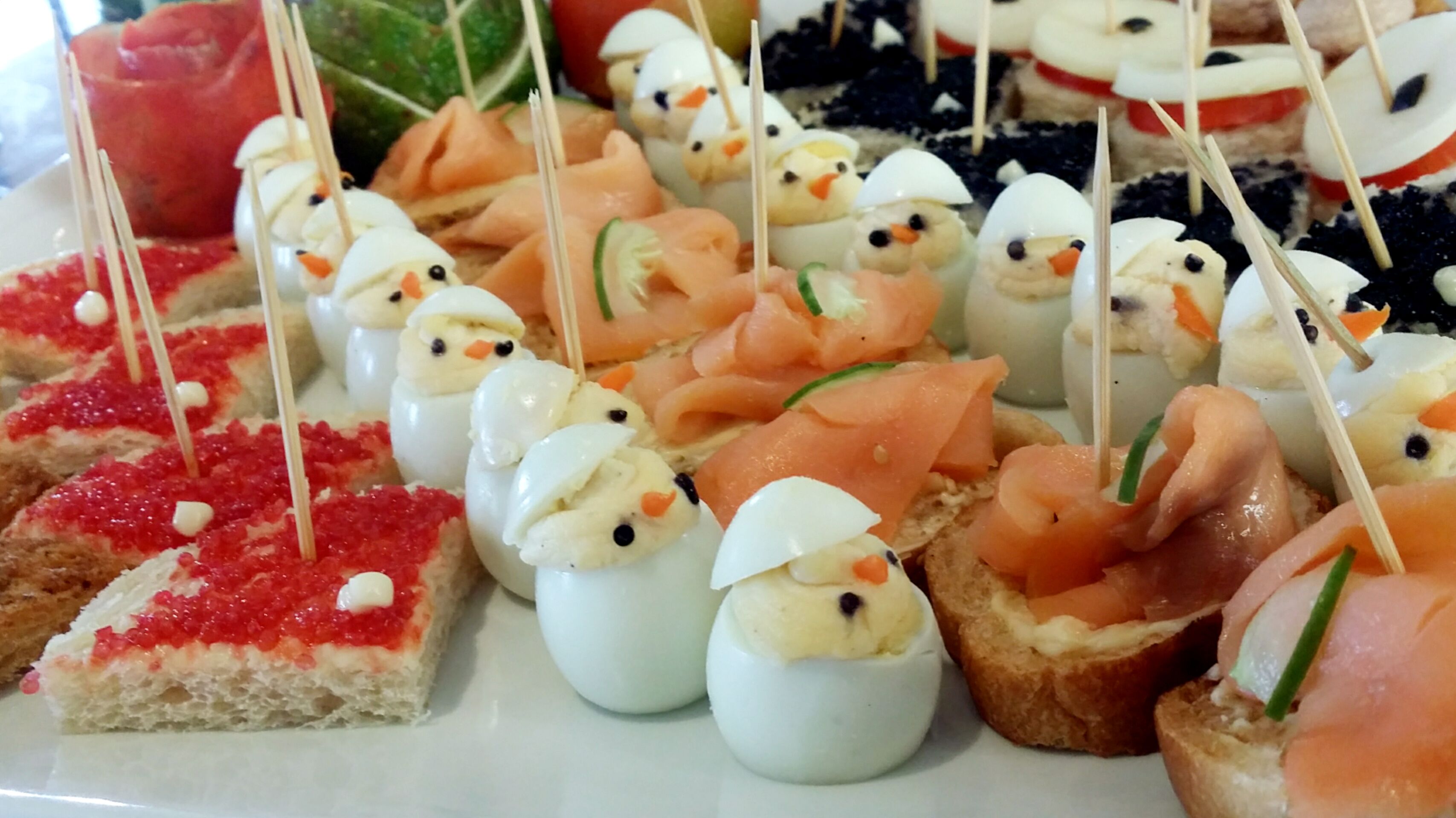 A variety of appetizers including smoked salmon and deviled eggs on bread.