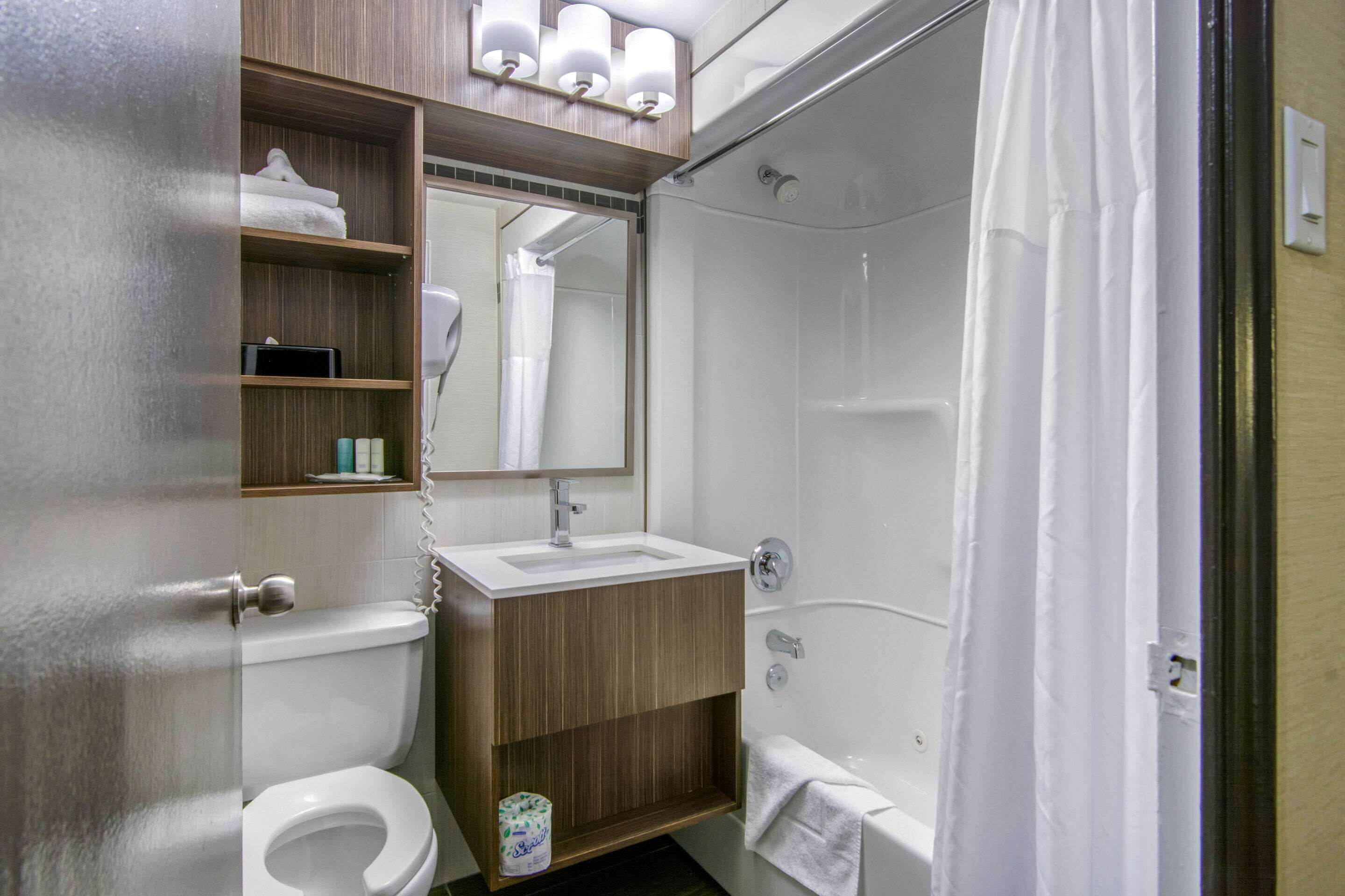 Un baño con inodoro, lavamanos y ducha.
