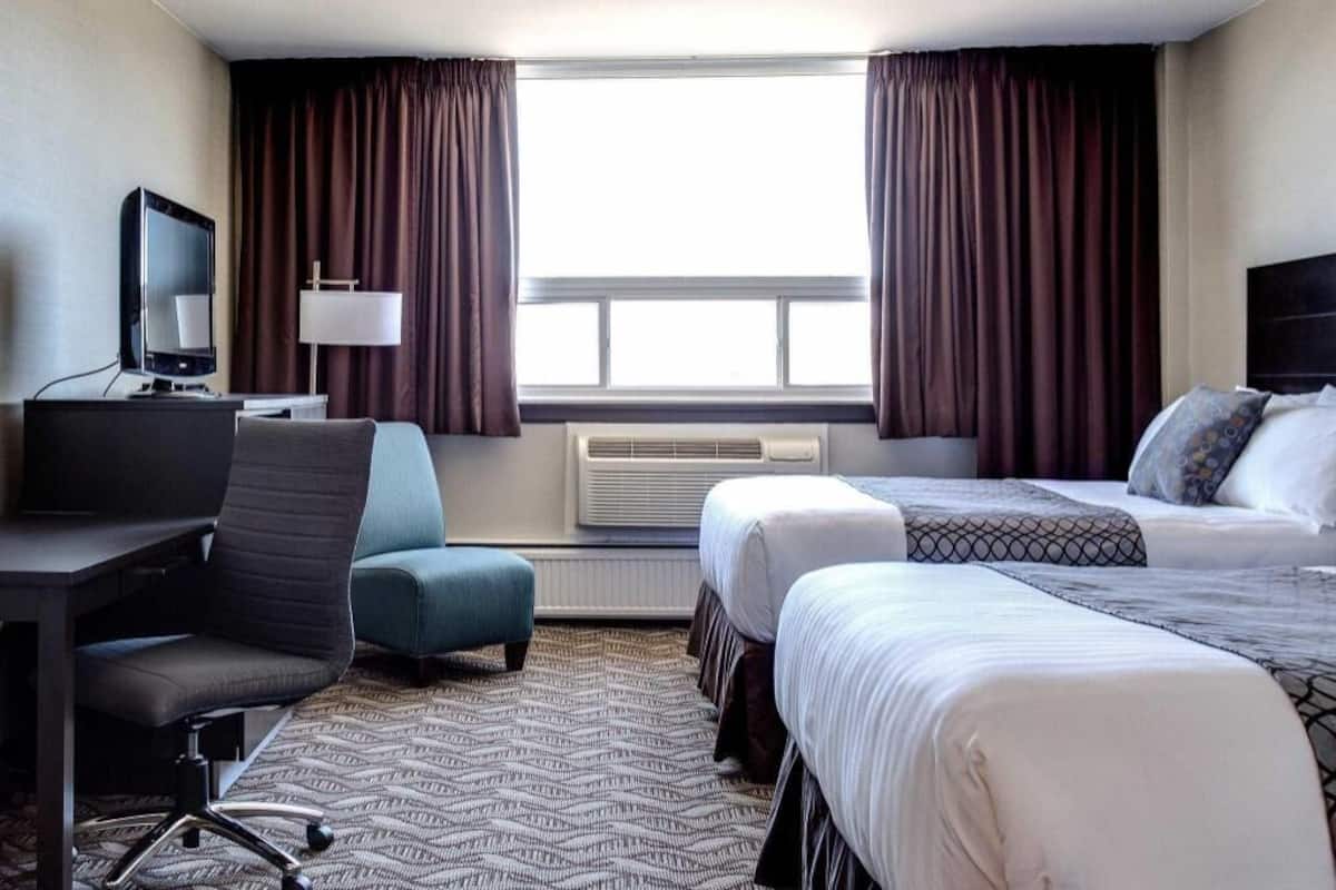 Camas com colchões pillow-top, escrivaninha, cortinas blackout