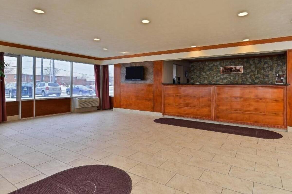 Un hall espacioso con una recepción, ventanas amplias y un suelo de baldosas planas.