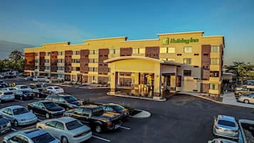 A Holiday Inn hotel with a parking lot filled with cars.