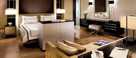 Une chambre d’hôtel moderne avec un grand lit, un bureau avec un ordinateur, un canapé et une télévision.