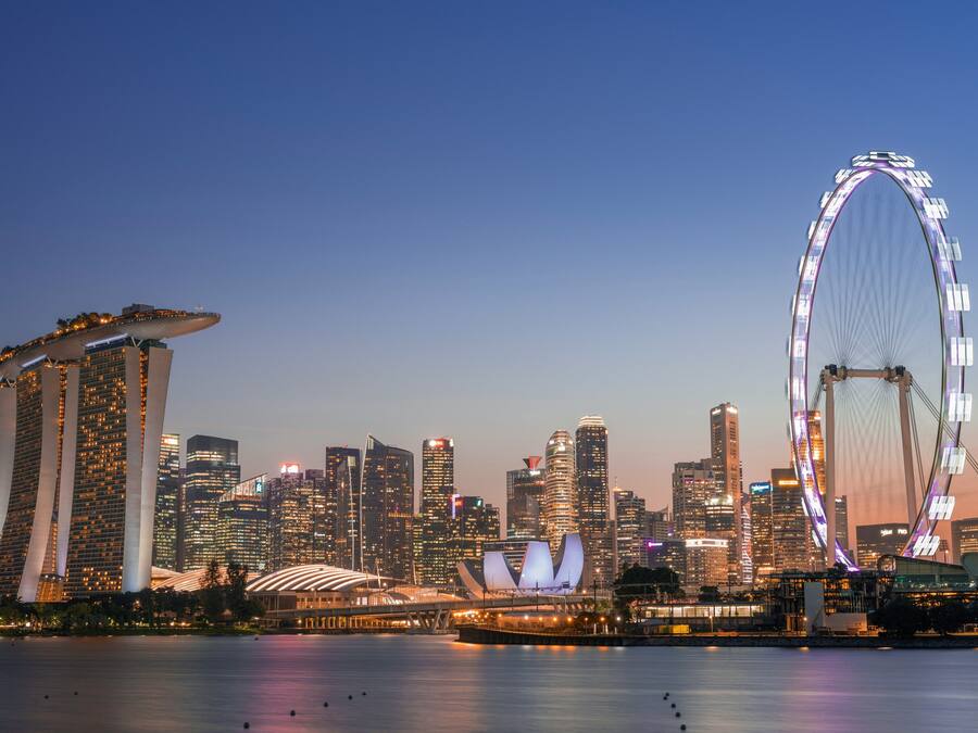 A city skyline with prominent buildings and a large Ferris wheel.