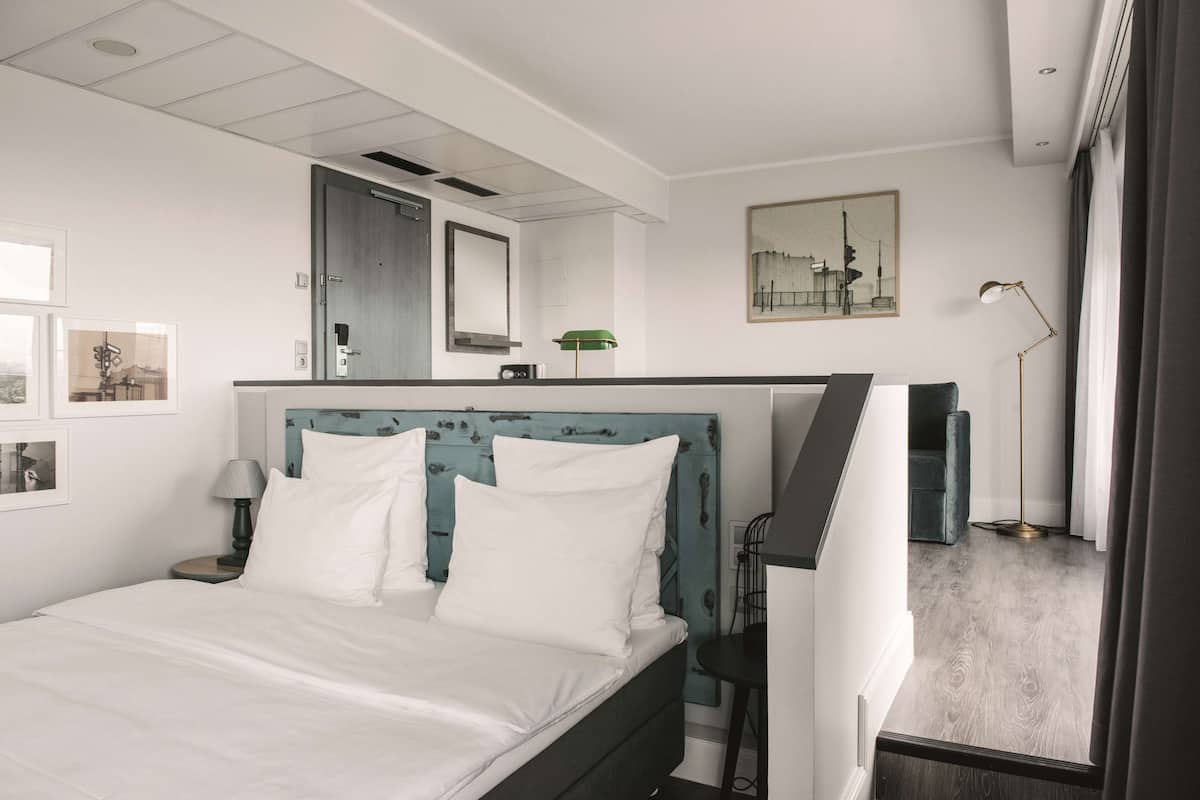 Une chambre à coucher moderne avec un lit, une table de chevet, un bureau et une chaise.