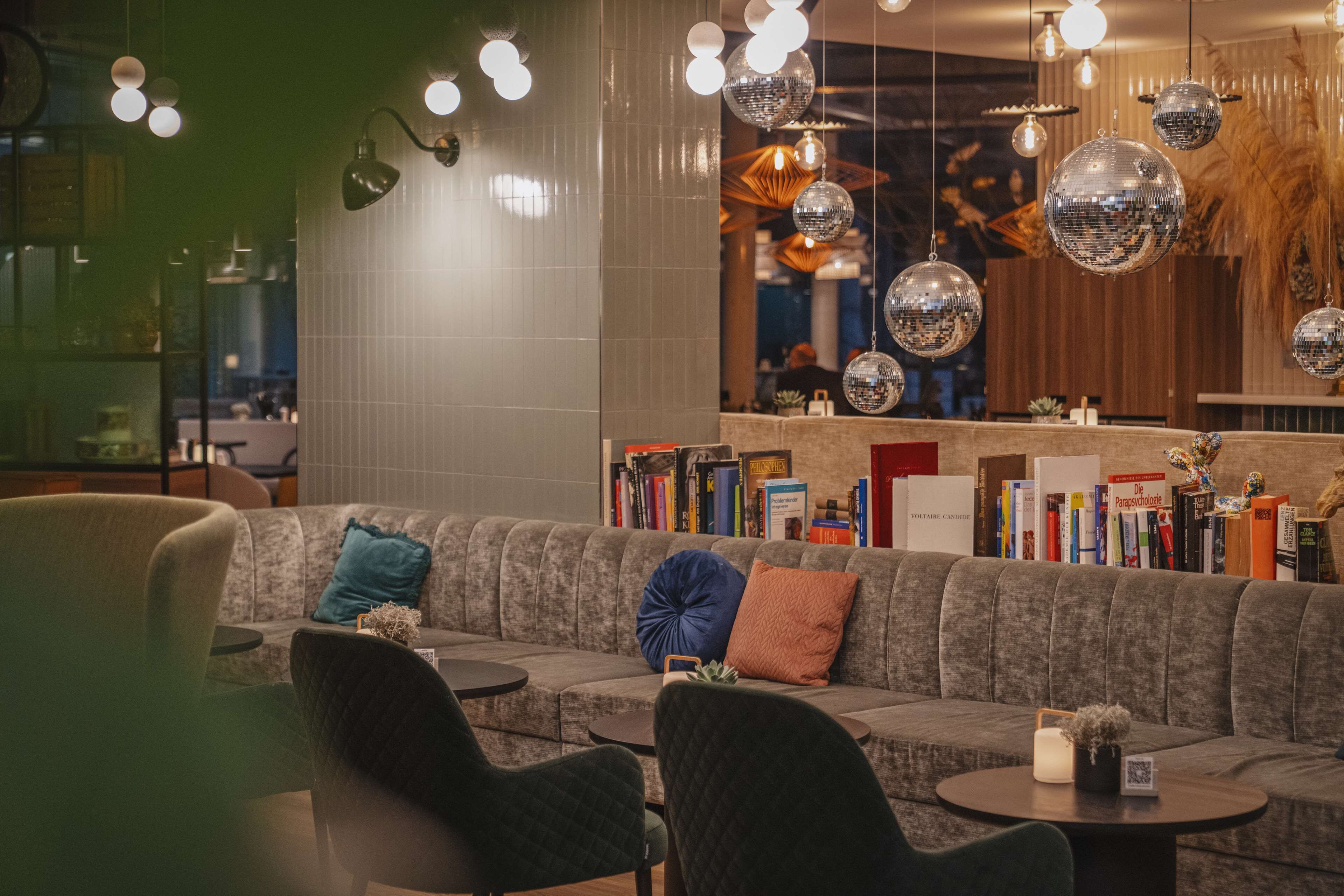 Et moderne loungeområde med sofa, lænestole og et lille bord.