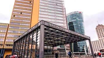 A modern building with a glass facade and a sign reading "BAHNHOF POTSDAMER PLATZ".