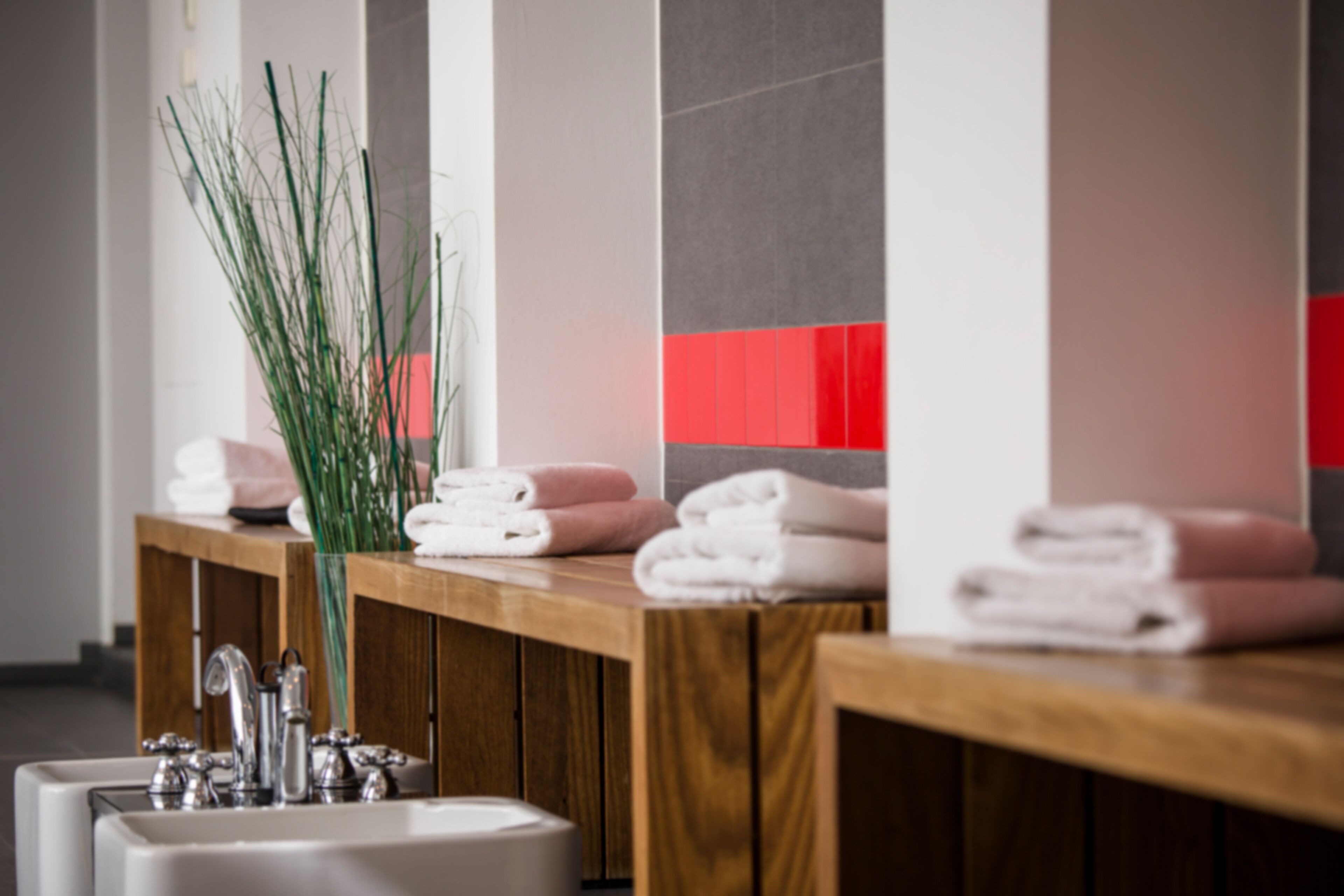 A bathroom with a wooden vanity, two sinks, and towels.