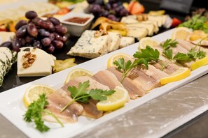 A variety of cheeses, fruits, and nuts arranged on a platter.