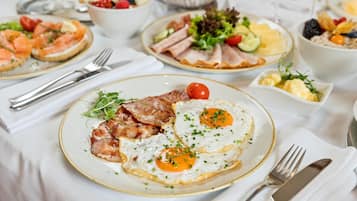 A breakfast setting with various dishes including eggs, bacon, and a salad.