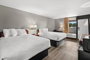 A hotel room with two beds, bedside tables, lamps, and a large window with curtains.